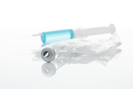 Medical syringe over container with medication - studio shotの写真素材