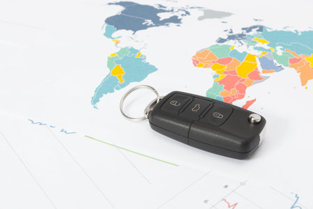 Transportation concept - close up studio shot of car key with calculator