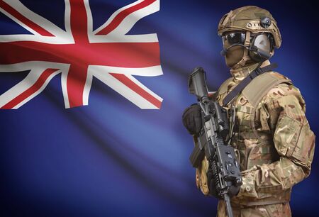 Soldier in helmet holding machine gun with national flag on background - New Zealandの写真素材