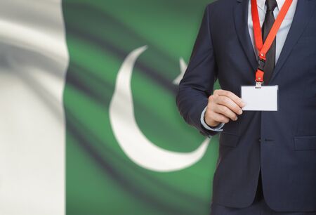 Businessman holding name card badge on a lanyard with a flag on background - Pakistanの写真素材