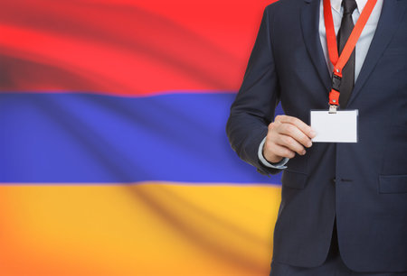 Businessman holding name card badge on a lanyard with a flag on background - Armeniaの写真素材