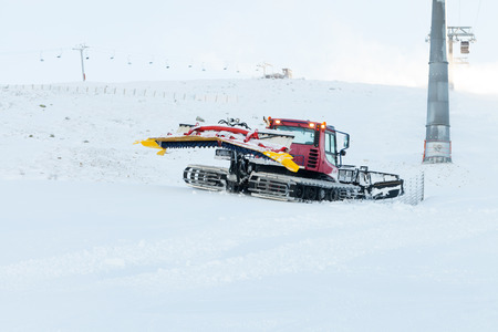 Ratrack preparing a slope for riding near cable car pillarの写真素材