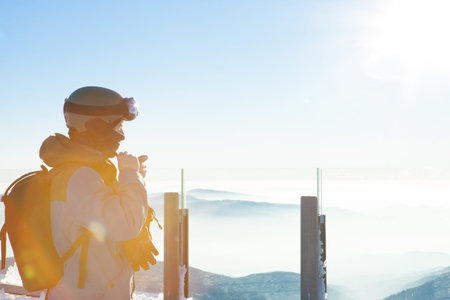 Male snowboarder getting ready for a downhill ride from the very top of a mountainの写真素材