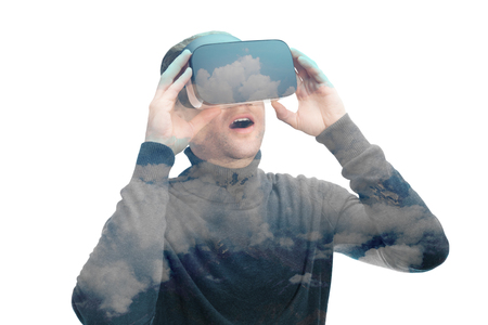 Indoors close up shot of male amazed by virtual reality glasses on white backgroundの写真素材