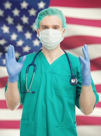 Surgeon holding his hands up with USA flag on backgroundの写真素材