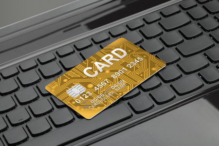Close up shot of golden color credit card over computers keyboard as symbol of online shoppingの写真素材