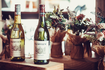 SEOUL, SOUTH KOREA - AUGUST 10, 2015: Two bottles of Fairview wine of year 2011 and 2012 with lots of flowers around - Seoul, South Koreaのeditorial素材