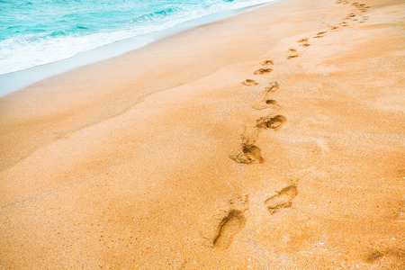 Yellow sand with footprints in the sand and turquoise color waters near it - Jeju Island, Koreaの写真素材