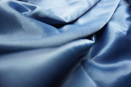 Blue satin background. Texture of blue satin fabric with foldsの写真素材