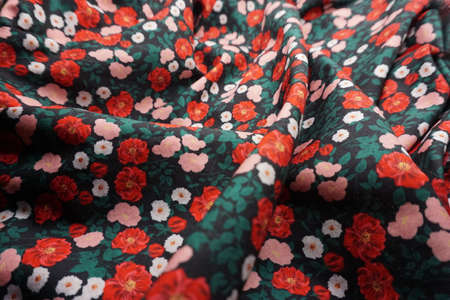 Fabric texture, background, pattern. Silk fabric is dark green with red flowers.の写真素材