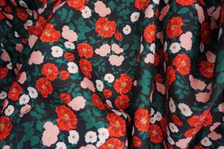 The texture of the fabric is dark green with red and white flowersの写真素材