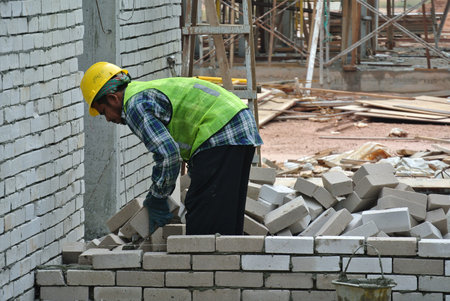 Construction workers laying bricks at construction site