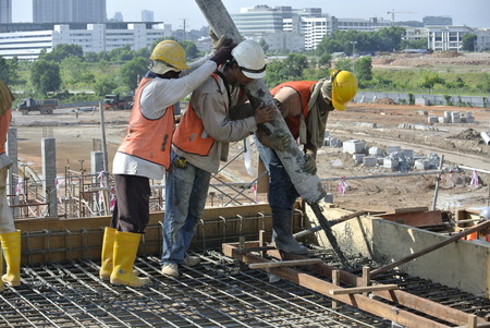 Construction Workers Using Hose from Concrete Pumpのeditorial素材