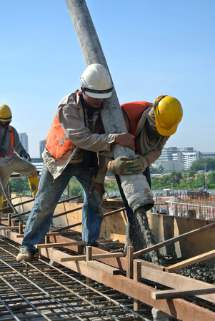 Construction Workers Using Hose from Concrete Pumpのeditorial素材
