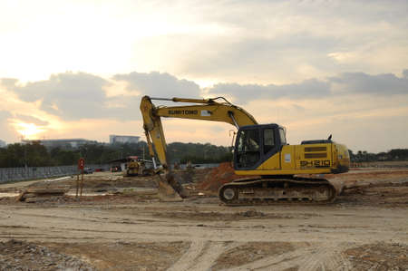 Excavators are heavy construction equipment consisting of a boom, stick, bucket and cab on a rotating platform. The house sits atop an undercarriage with tracks or wheels.のeditorial素材
