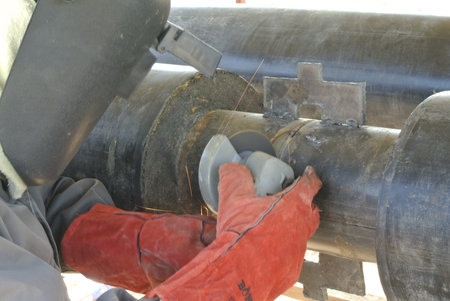 Welders using grinder to smooth welding surface. He is a professional who knows the method to use...