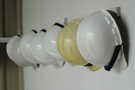 Hard hat is a type of helmet predominantly used in workplace environments such as industrial or construction sites to protect the head from injury due to falling objects, impact with other objects, debris, rain, and electric shock.の写真素材