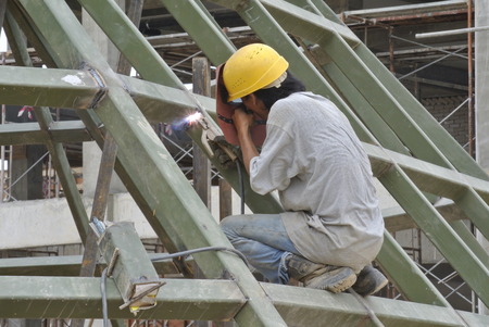 Welder wearing protective mask welding mild steel metal at the construction site on August 07, 2014 at Selangor, Malaysia.の写真素材