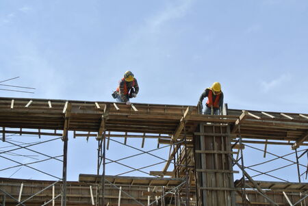 Construction workers fabricating beam formwork on July 25, 2014 at Sepang, Malaysia. Formwork is fabricated from wood and plywood.の写真素材