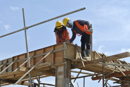 Construction workers fabricating beam formwork on July 25, 2014 at Sepang, Malaysia. Formwork is fabricated from wood and plywood.のeditorial素材