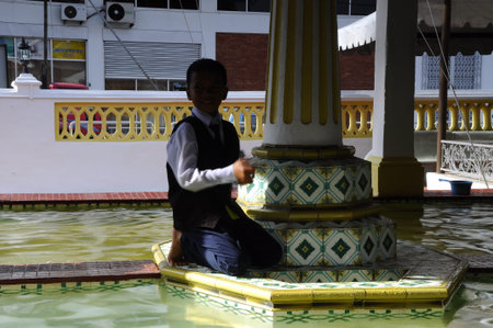 A boy at ablution fountain at Masjid Kampung Hulu in Malacca, Malaysiaのeditorial素材