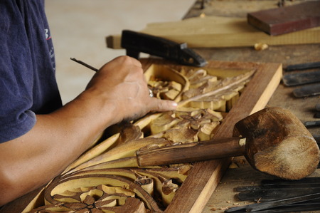 Skilled craftsman doing wood carving using traditional methodの写真素材