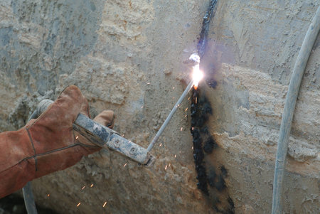 Welders welded bore pile metal casing at the construction site.