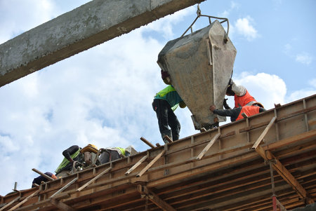 Group of construction workers casting beam at Selangor, Malaysia. The concrete was lifted using...