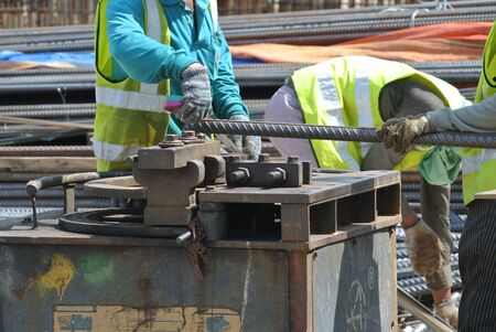 Construction workers bending the reinforcement bar at the bar bending yard in the construction site.の写真素材