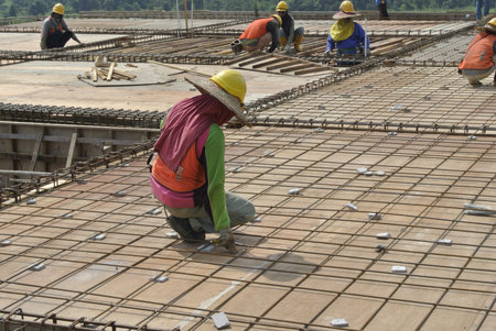 Group of construction workers fabricating floor slab reinforcement bar and formworkの写真素材