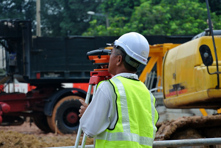 SELANGOR, MALAYSIA - JULY, 2015: Surveyor using survey equipment at the construction in Selangor, Malaysiaのeditorial素材