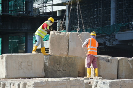 SELANGOR, MALAYSIA  MARCH 2015: Construction workers arranging load test block at the construction site in Selangor, Malaysia. The block used to test the piling integrity.のeditorial素材