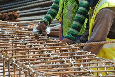 Group of construction workers fabricating pile cap steel reinforcement bar at the construction site.