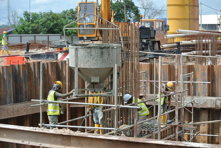 SELANGOR, MALAYSIA  SEPTEMBER 2014: A group of construction workers pouring concrete using concrete...
