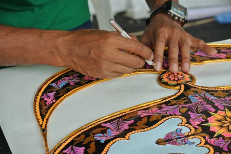 Malaysian kite maker working on a kite in his workshopの写真素材