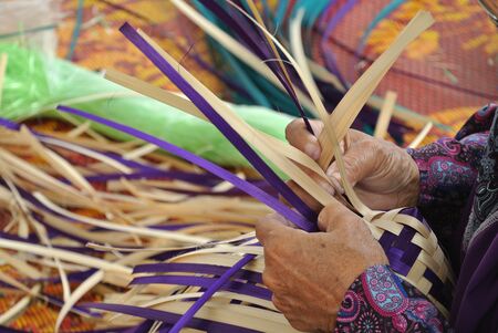 SELANGOR, MALAYSIA  SEPTEMBER 6, 2015: An old lady was weaving traditional food cover woven from pandanus leavesの写真素材