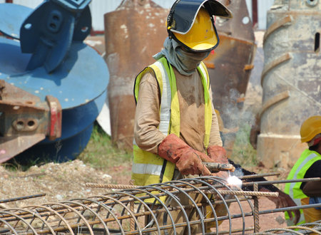Welder wearing protective mask welding metal at the construction site