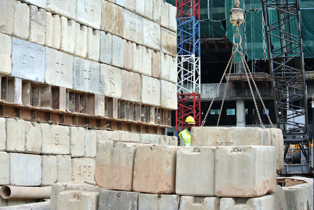 SELANGOR, MALAYSIA  APRIL 08, 2015: Construction workers stacking the maintain load test block at the construction site in Selangor, Malaysia. The block used to test the piling integrity.のeditorial素材