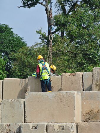 SELANGOR, MALAYSIA  APRIL 08, 2015: Construction workers stacking the maintain load test block at the construction site in Selangor, Malaysia. The block used to test the piling integrity.のeditorial素材