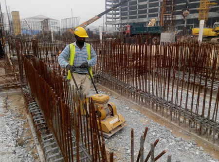 SELANGOR, MALAYSIA  SEPTEMBER 11, 2014: Builder worker at sand ground compaction with vibration...