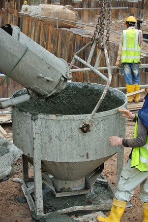 SELANGOR, MALAYSIA  SEPTEMBER 09, 2015: A truck load of concrete is poured concrete into the concrete bucket at the construction site in Selangor, Malaysia on September 09, 2015.のeditorial素材