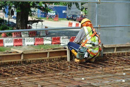 Construction workers fabricating floor slab reinforcement bar at the construction site in Malacca, Malaysiaの写真素材