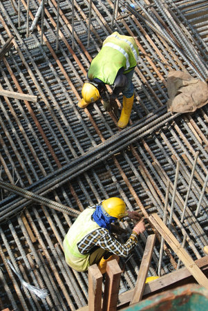 MALACCA, MALAYSIA  SEPTEMBER 22, 2015: Group of construction workers fabricating steel reinforcement...