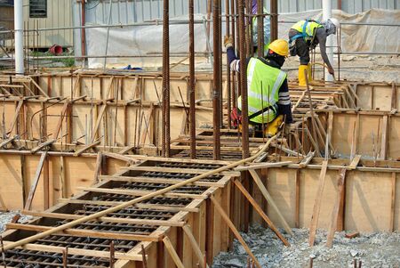 SELANGOR, MALAYSIA  OCTOBER 17, 2015: Group of construction workers fabricating ground beam timber form work at construction site in Selangor, Malaysia on October 17, 2015.のeditorial素材