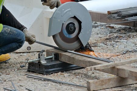JOHOR, MALAYSIA  SEPTEMBER 15, 2015: A construction worker using the portable all purpose pipe cutter machine to cut piece of woods at the construction site in Johor, Malaysia on September 15, 2015.のeditorial素材