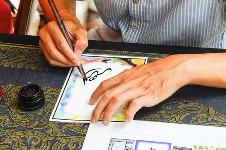 A man wrote an Arab calligraphy words on piece of paper.の写真素材