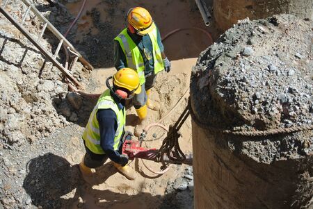 JOHOR, MALAYSIA -JANUARY 13, 2015: A construction workers cutting foundation pile using hacking method at the construction site. He using the heavy duty mobile hacker machine.のeditorial素材
