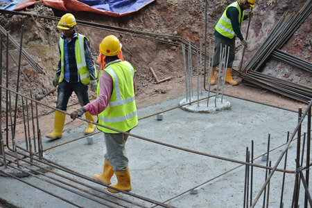 MALACCA, MALAYSIA -JUNE 27, 2016: Construction workers fabricating steel reinforcement bar at the...