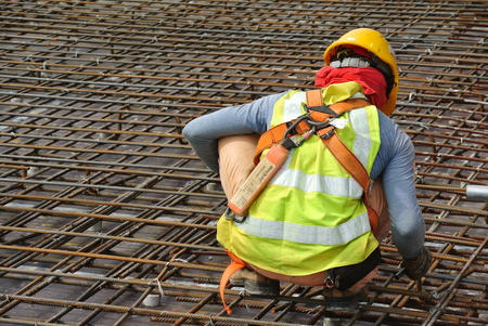 MALACCA, MALAYSIA -JUNE 27, 2016: Construction workers fabricating steel reinforcement bar at the construction site in Malacca, Malaysia. The reinforcement bar was ties together using tiny wire.のeditorial素材