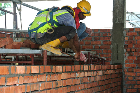 JOHOR, MALAYSIA -APRIL 05, 2016: Bricklayer install clay bricks for building walls.のeditorial素材